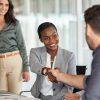 partner Happy black businesswoman and businessman shaking hands at meeting. Professional business executive leaders making handshake agreement. Happy business man closing deal at negotiations with african american woman.